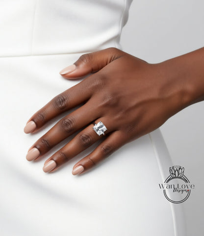 A close-up of a hand wearing a large diamond ring, with a white dress visible in the background.