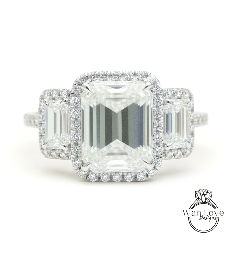 A close-up of a diamond engagement ring with a large central diamond surrounded by smaller diamonds on either side.