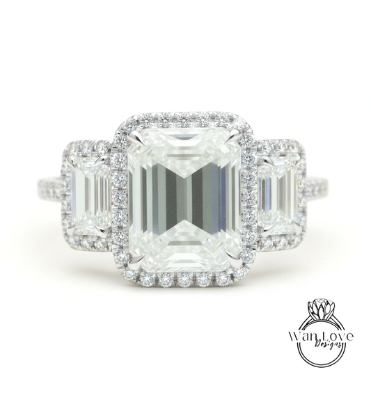 A close-up of a diamond engagement ring with a large central diamond surrounded by smaller diamonds on either side.