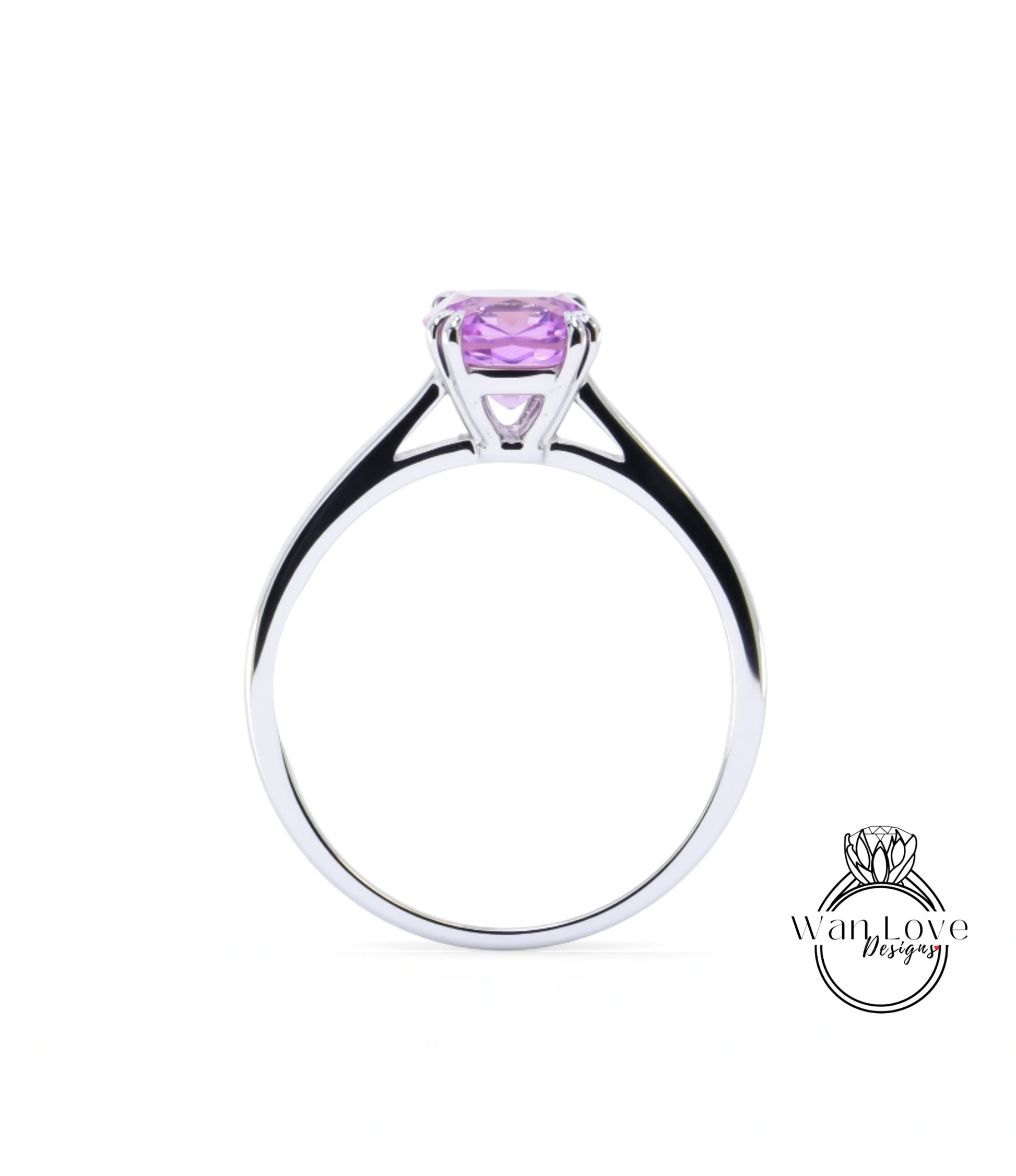 A silver ring with a large purple gemstone, likely a sapphire, set in the center.