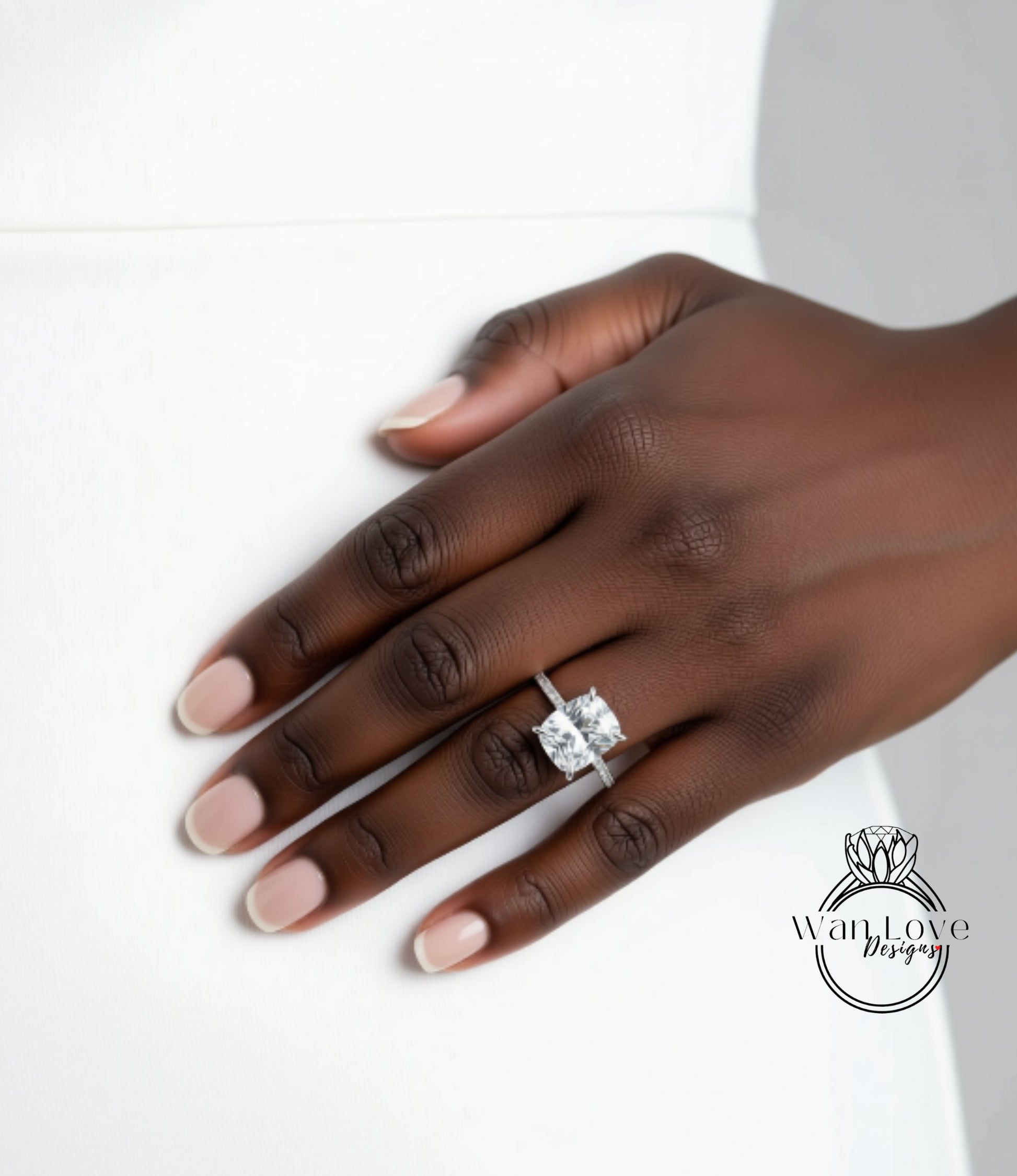 A close-up of a hand wearing a diamond engagement ring.