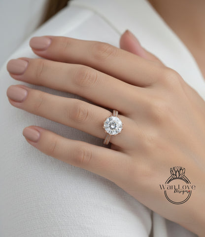 A close-up of a person's hand wearing a large, round diamond engagement ring.