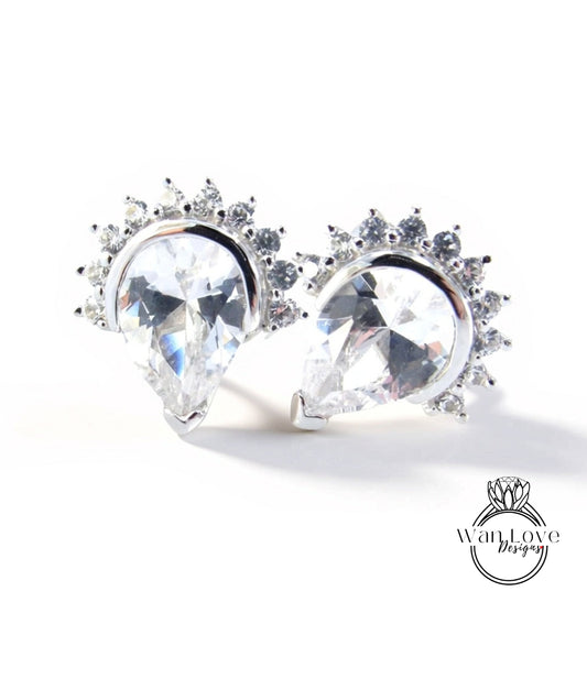 A pair of elegant earrings with large, clear gemstones set in a decorative metal frame.