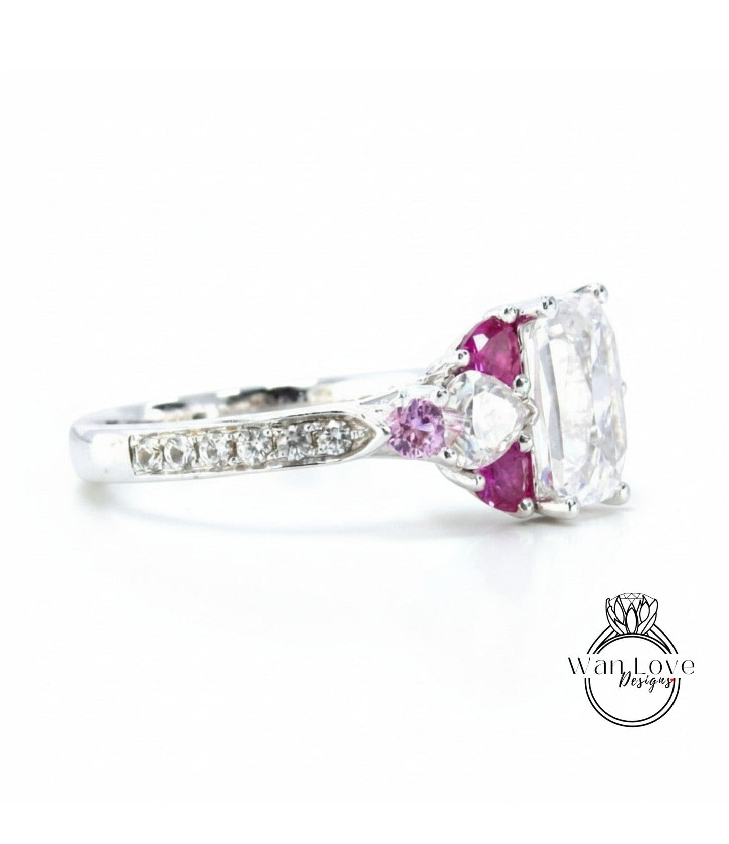 A close-up view of a silver ring with a large central gemstone surrounded by smaller gemstones and a row of smaller diamonds along the band.