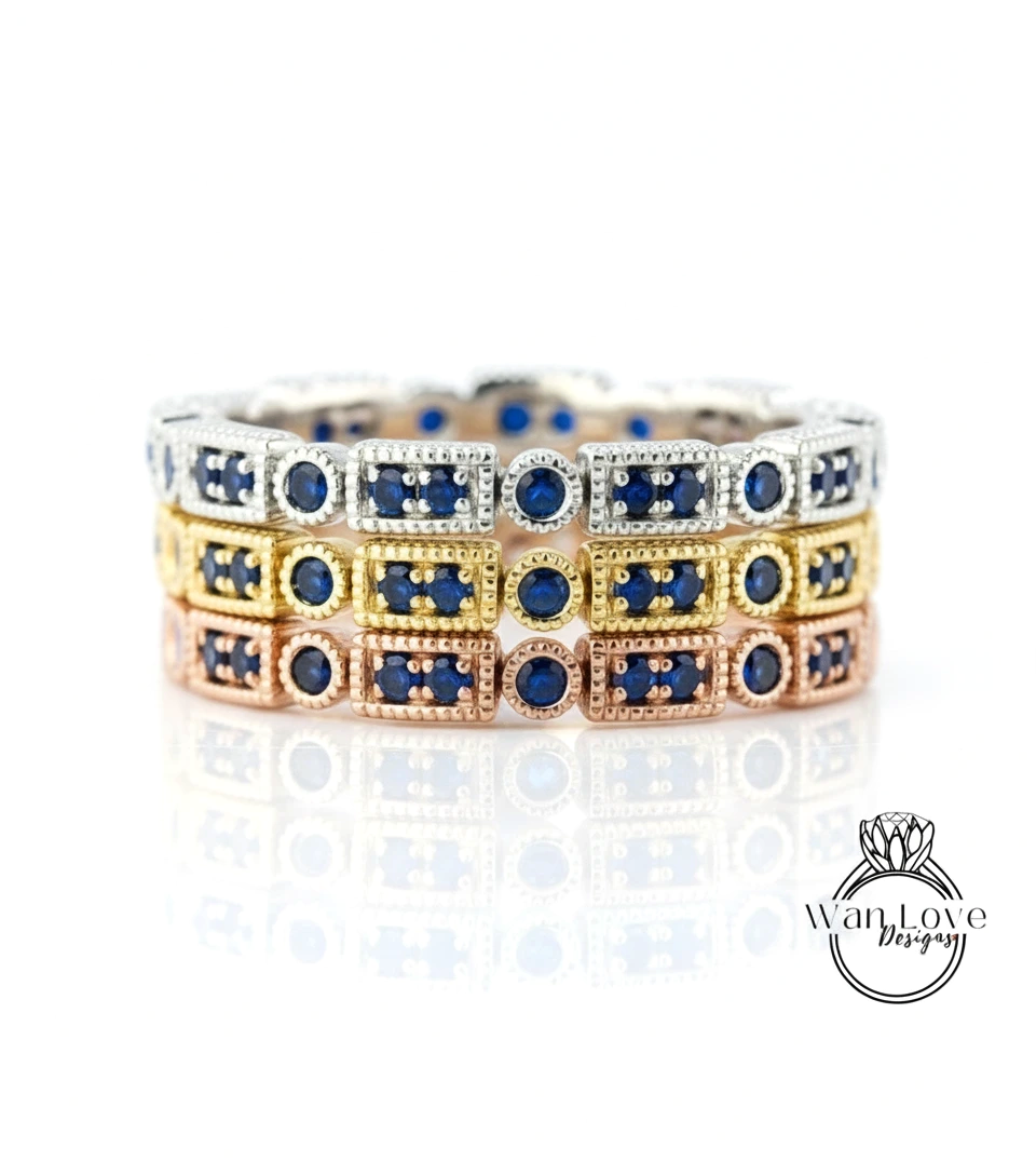 A stack of three rings with blue gemstones set in gold and silver, arranged in a circular pattern.