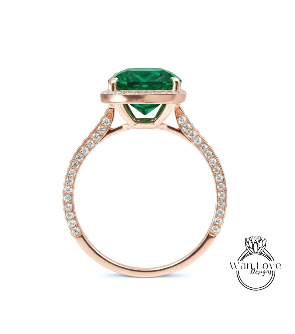 A rose gold ring with a large, vibrant green gemstone set in the center.