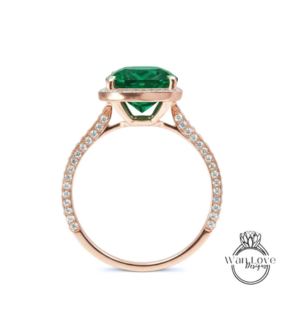 A rose gold ring with a large, vibrant green gemstone set in the center.