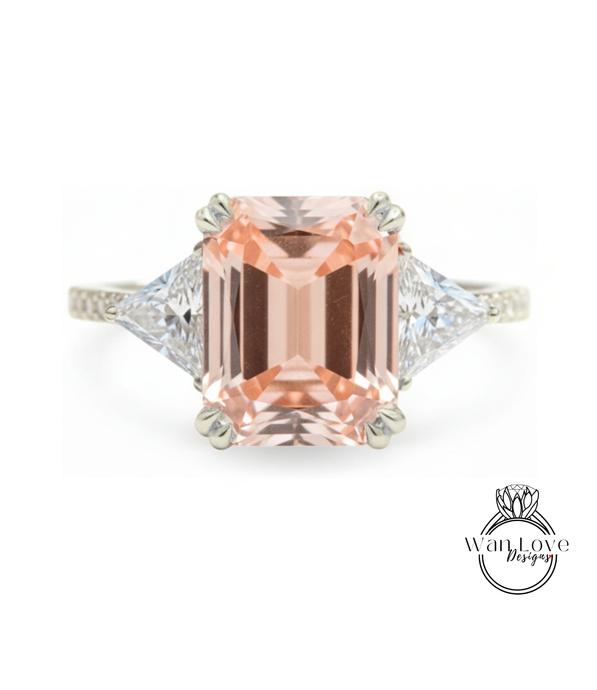 A large, peach-colored gemstone engagement ring with a diamond-encrusted band and two triangular-shaped diamonds on either side.