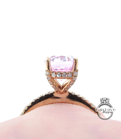 A close-up view of a pink gemstone ring with a large central gemstone surrounded by smaller diamonds set in a gold-toned band.