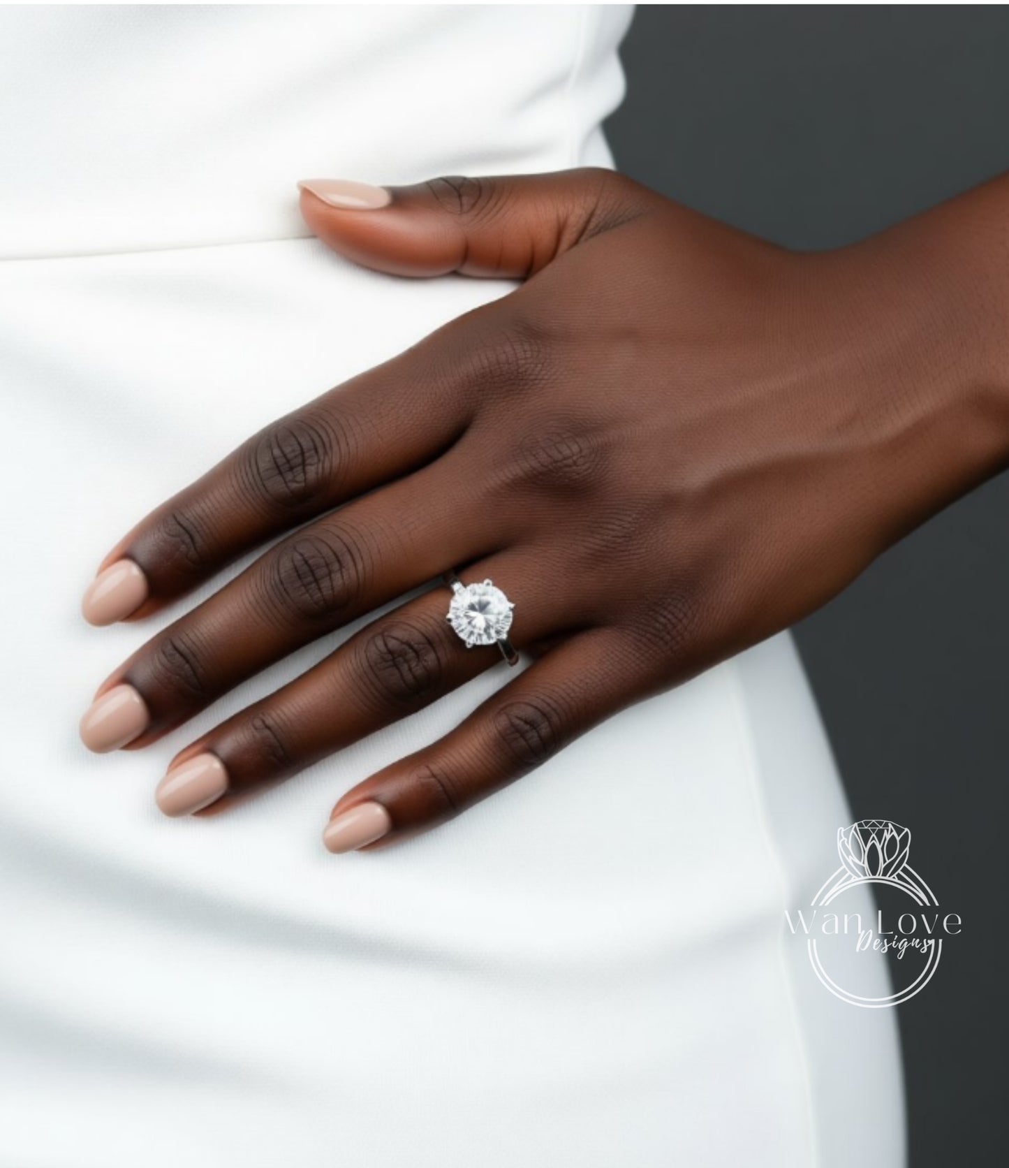 A close-up of a hand wearing a diamond engagement ring.