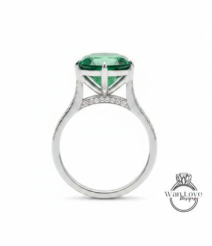 A silver ring with a large, green gemstone set in the center.