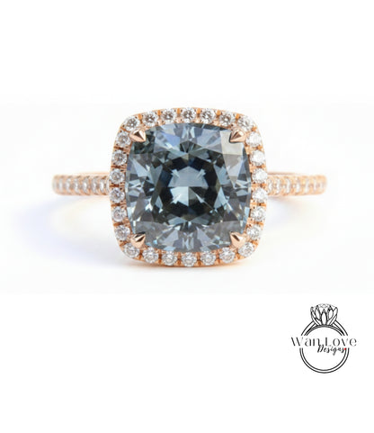 A large, blue gemstone engagement ring with a halo of smaller diamonds around the center stone.