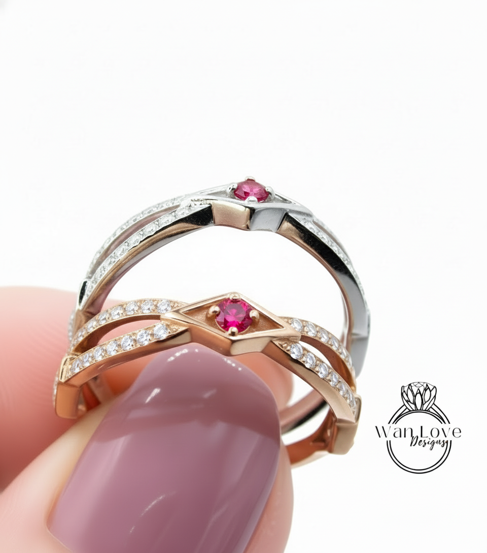 A close-up of a person's hand holding a ring with a pink gemstone and a silver band, with the ring being held against a white background.