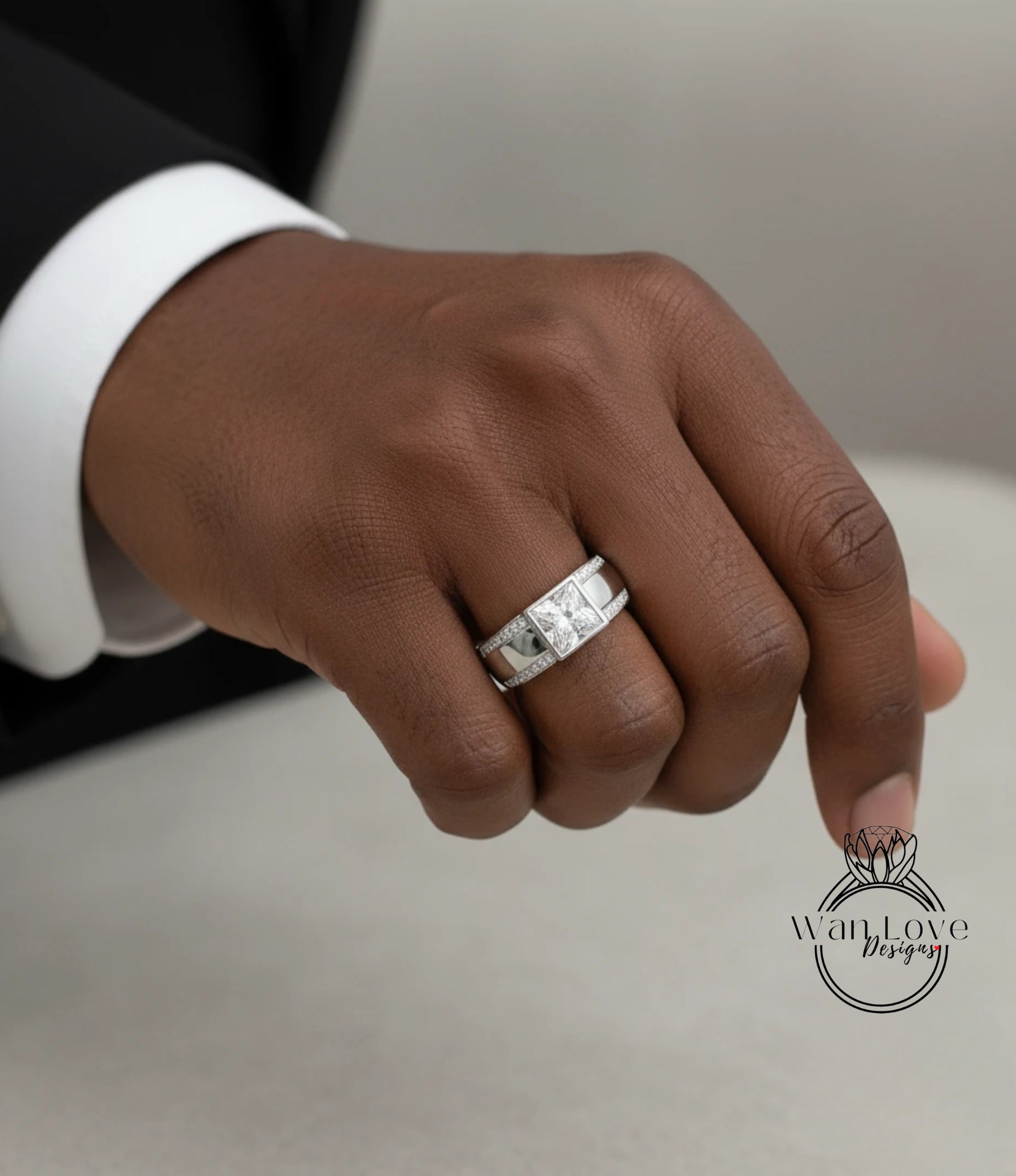 A close-up of a person's hand wearing a silver ring on the ring finger.