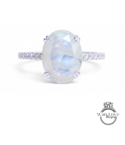 A ring with a large oval-shaped stone, possibly a moonstone, set in a silver band.