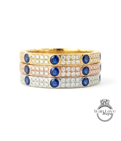 A stack of three rings with blue gemstones and diamonds set in gold and silver.