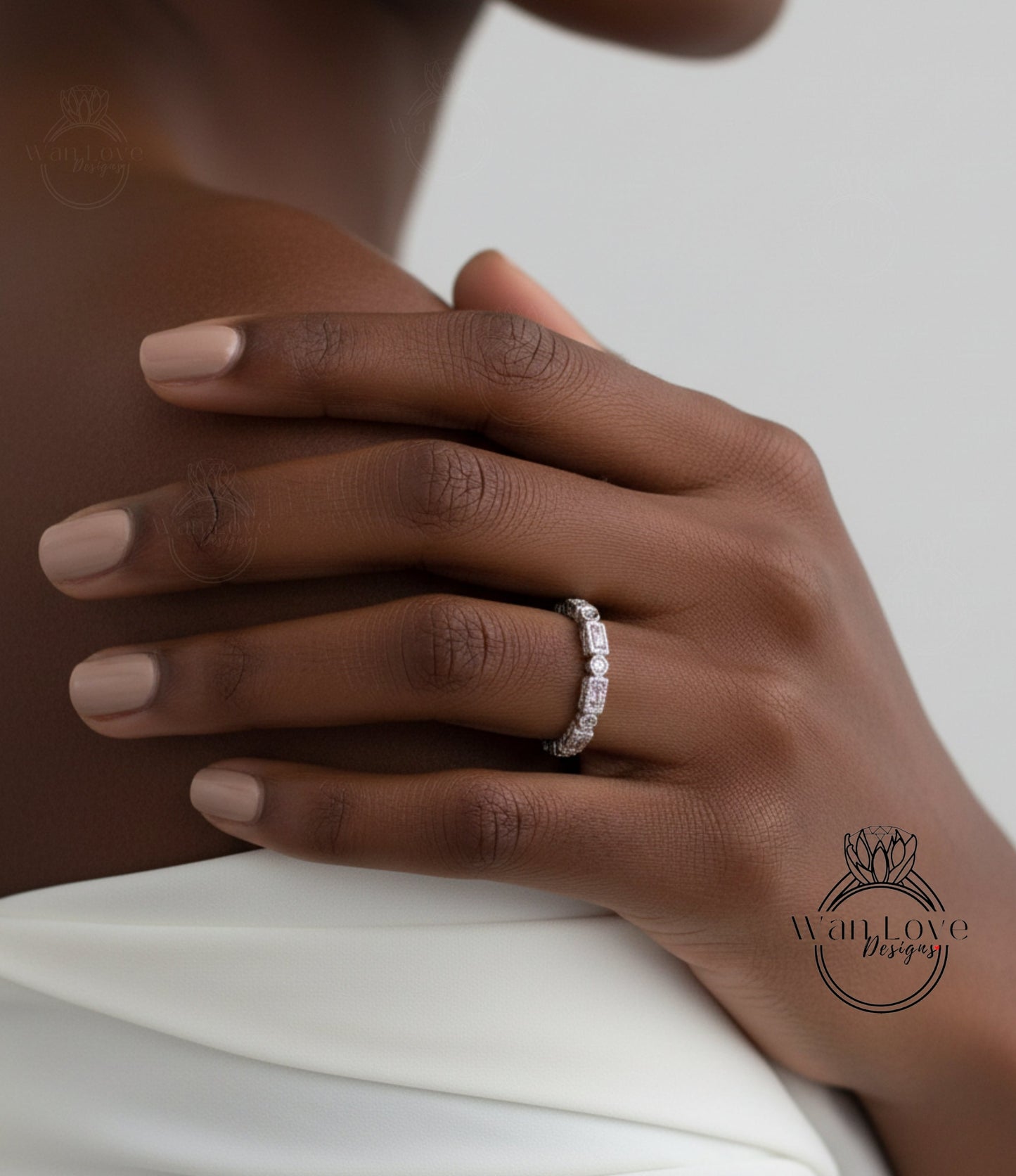 A close-up of a person's hand wearing a diamond ring on the ring finger.