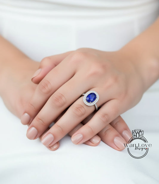 A close-up of a person's hands wearing a ring with a large blue gemstone.