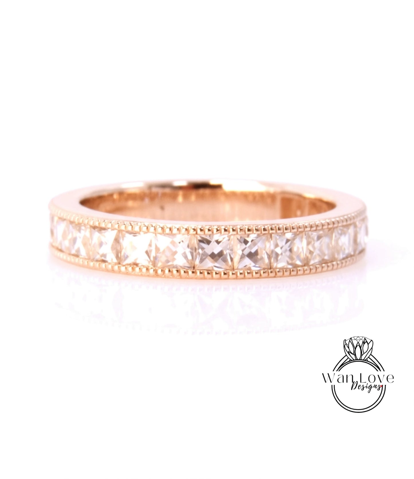 A gold band ring with a row of clear gemstones set in it.