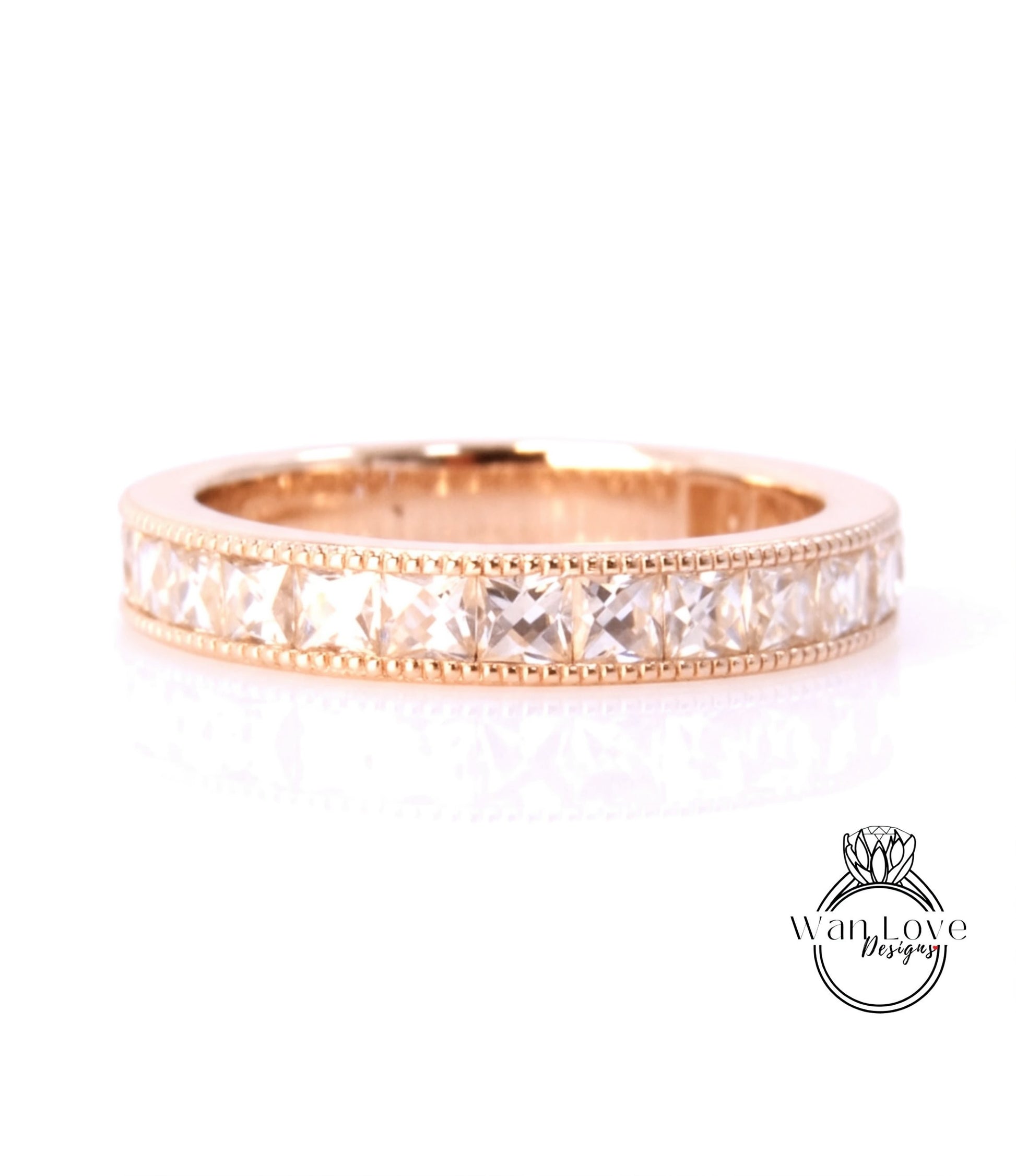 A gold band ring with a row of clear gemstones set in it.