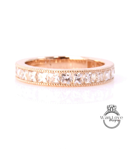A gold band ring with a row of clear gemstones set in it.