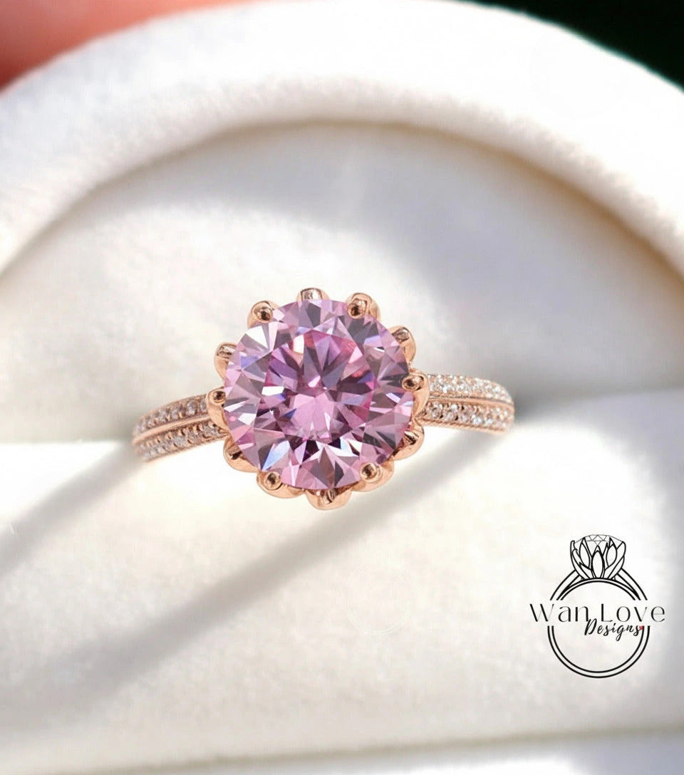 A close-up image of a pink diamond ring with a large central gemstone surrounded by smaller diamonds on the band.