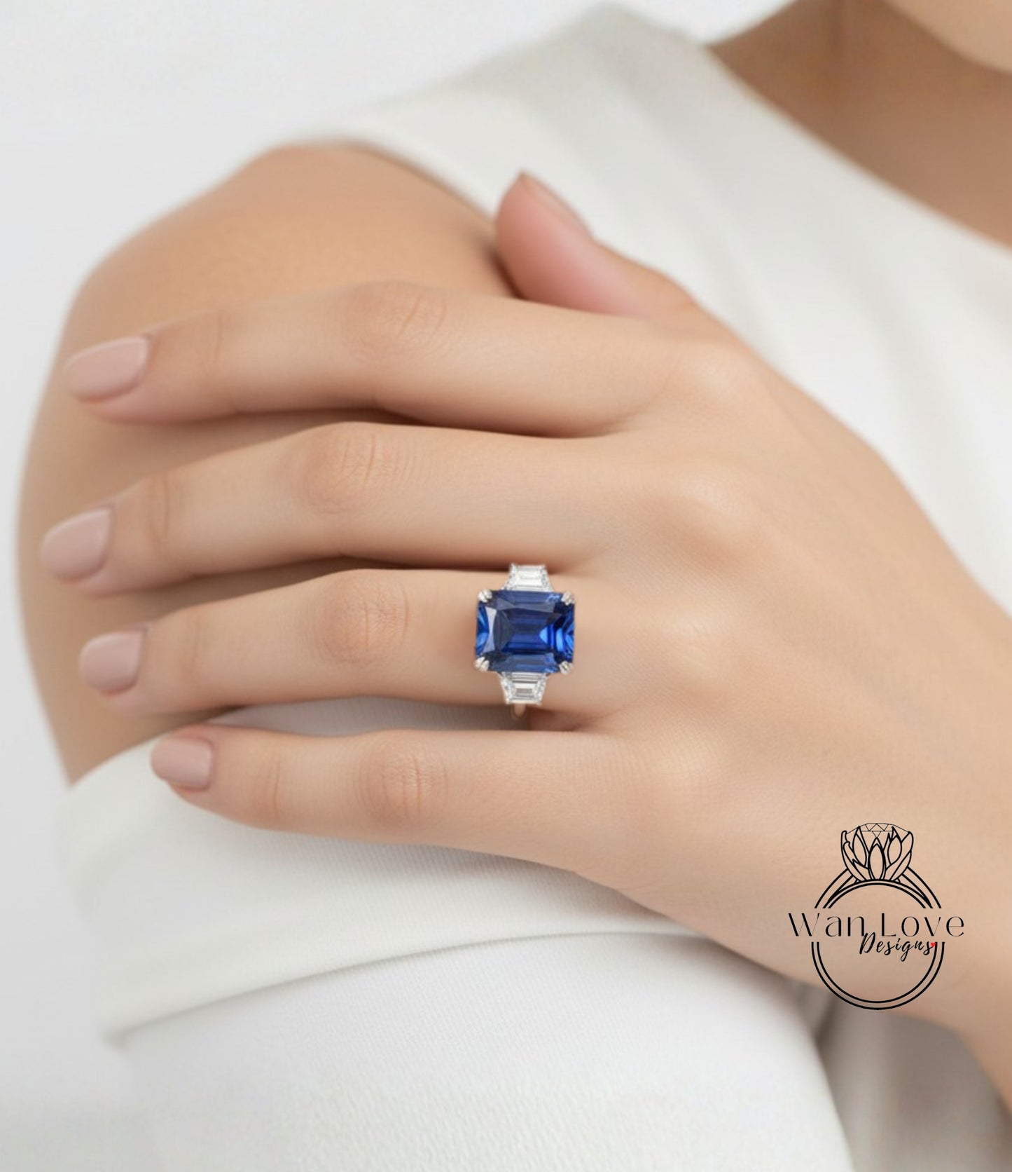 A close-up of a person's hand wearing a large, blue gemstone ring.