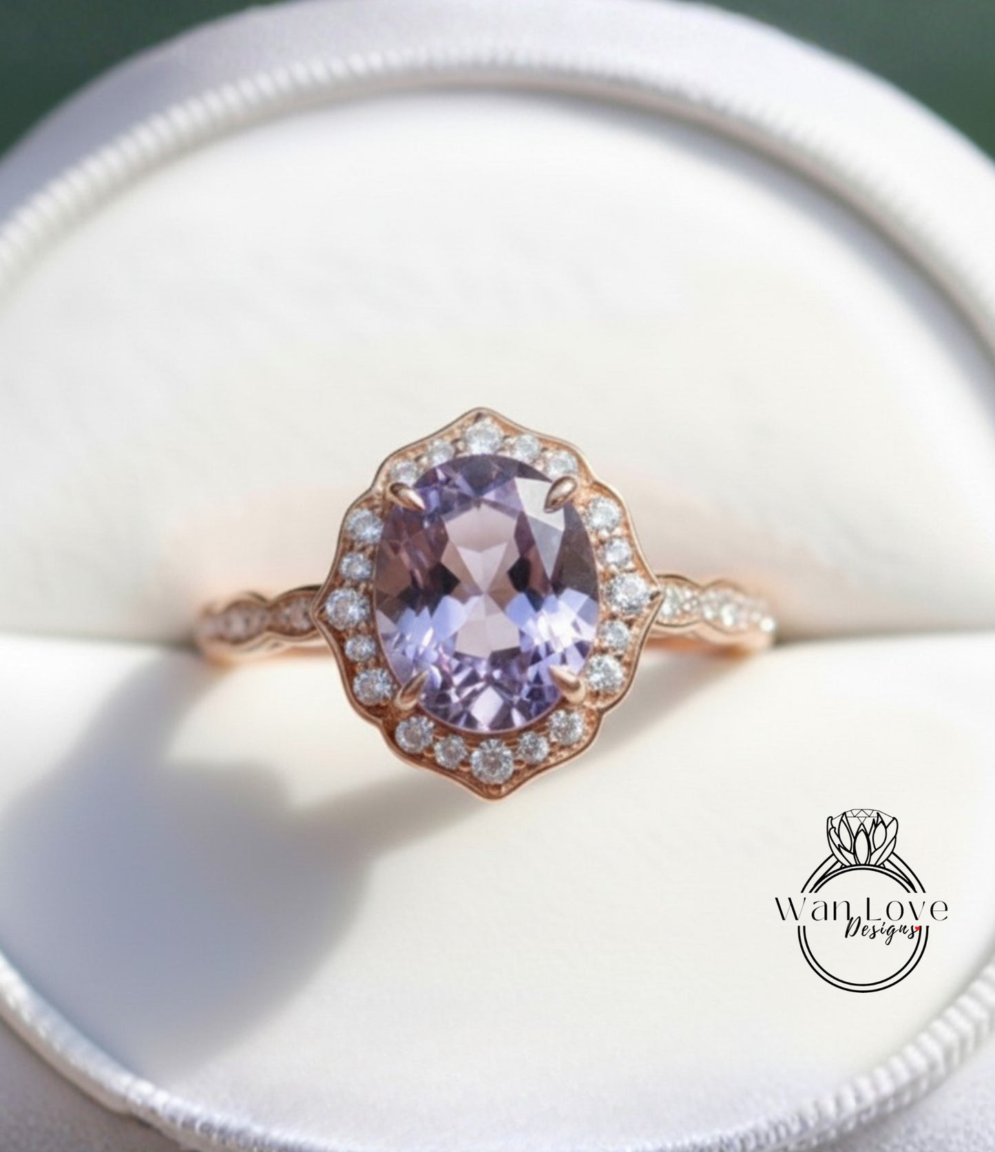 A close-up image of a gold ring with a large oval-shaped purple gemstone, surrounded by smaller diamonds, placed in a white box.