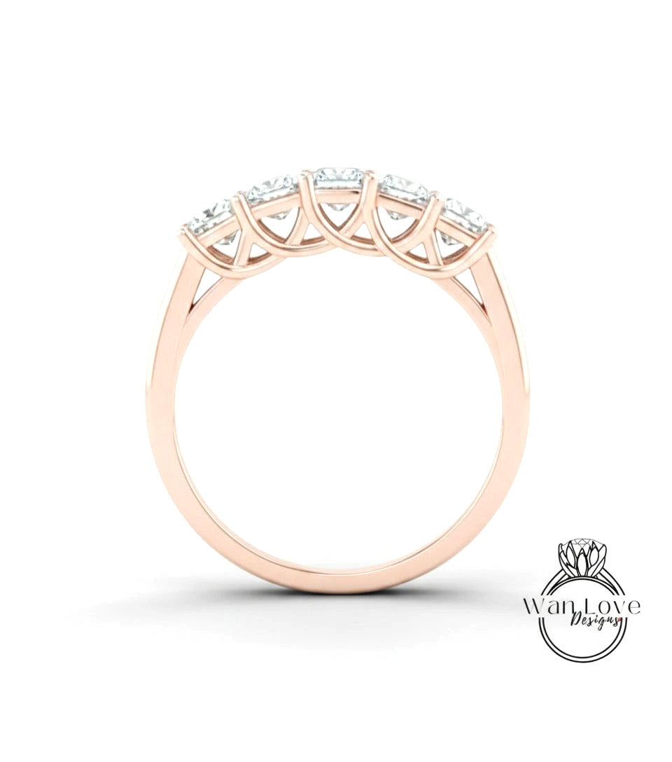A gold ring with a row of diamonds set in the center.
