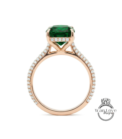 A gold ring with a large green gemstone set in the center, surrounded by smaller diamonds.