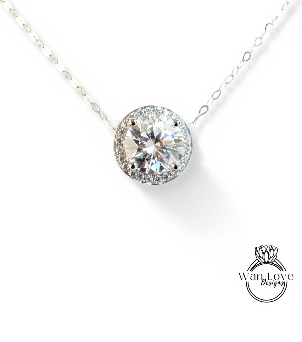 A close-up view of a delicate necklace with a large, round diamond pendant set in a halo of smaller diamonds.