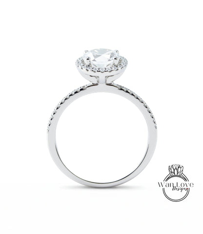 A silver engagement ring with a large central diamond surrounded by smaller diamonds, set in a halo of smaller diamonds.