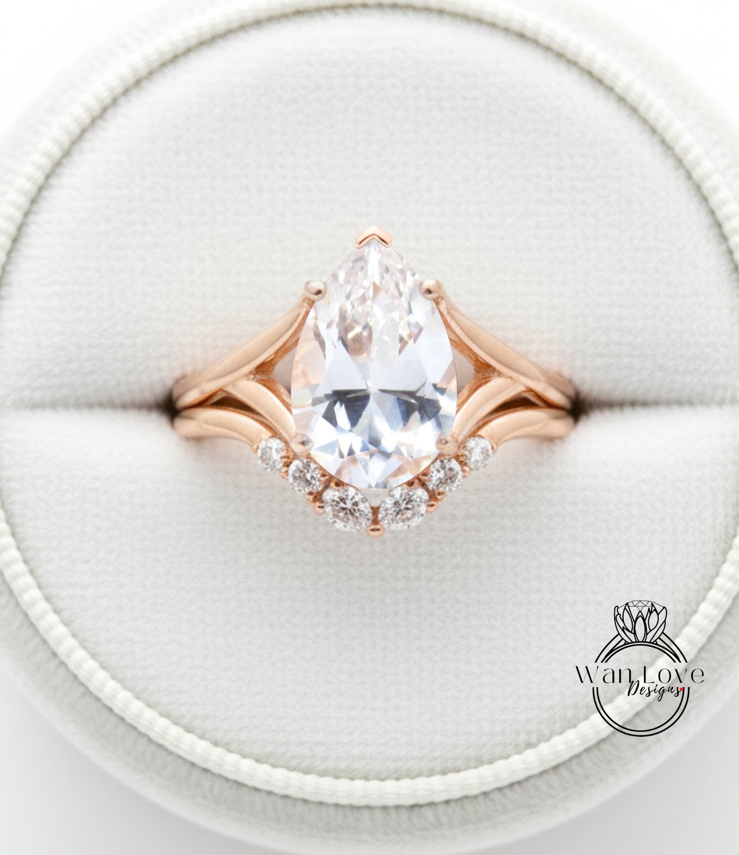 A close-up image of a gold ring with a large pear-shaped diamond set in the center, surrounded by smaller diamonds.