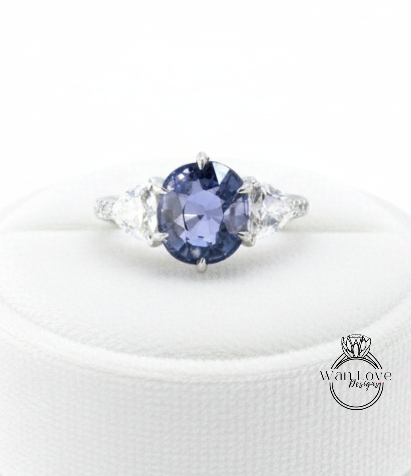 A close-up image of a diamond engagement ring with a large blue gemstone surrounded by smaller diamonds.
