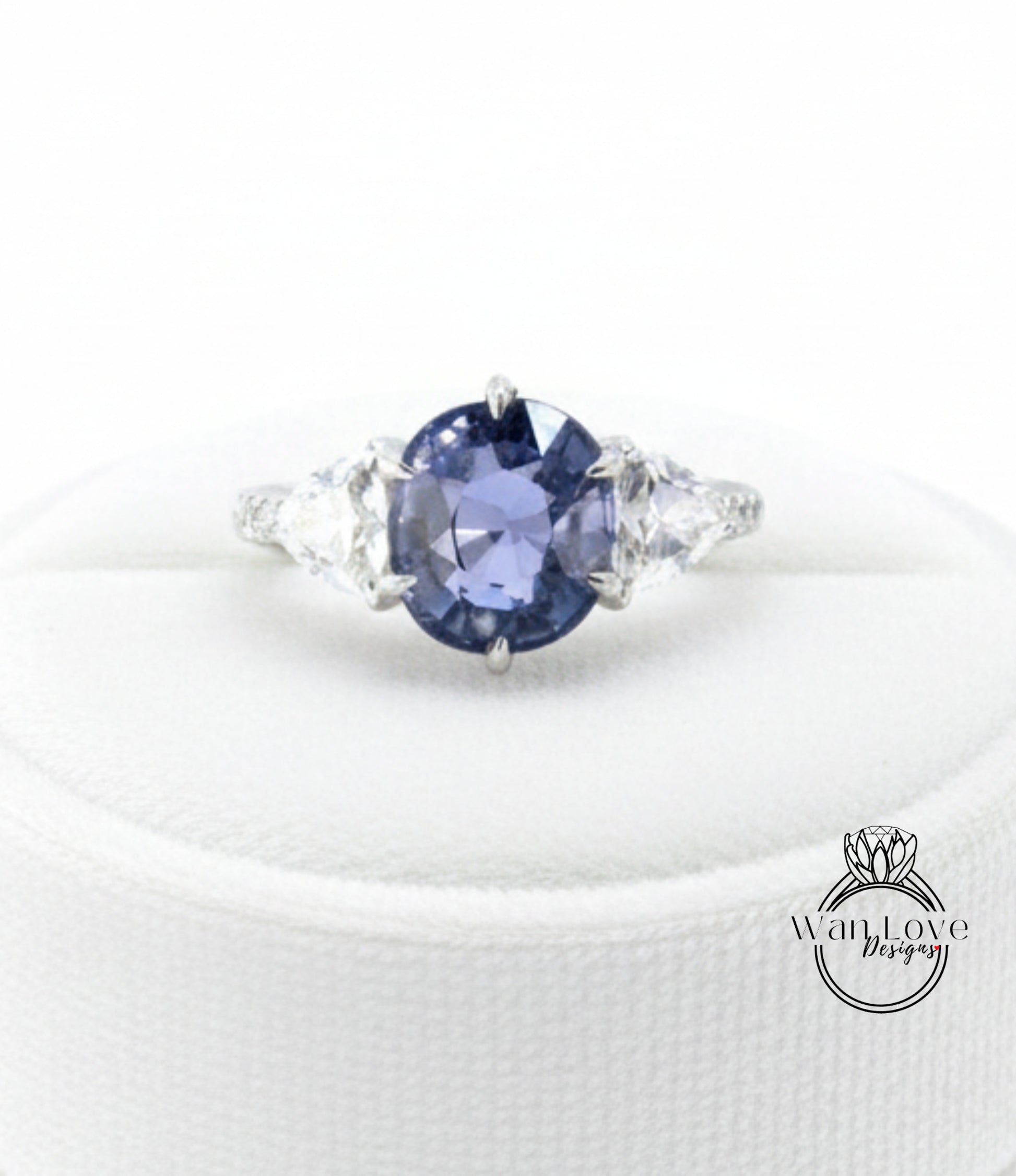 A close-up image of a diamond engagement ring with a large blue gemstone surrounded by smaller diamonds.
