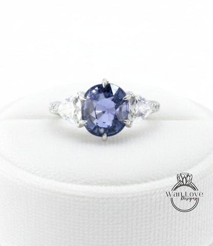 A close-up image of a diamond engagement ring with a large blue gemstone surrounded by smaller diamonds.