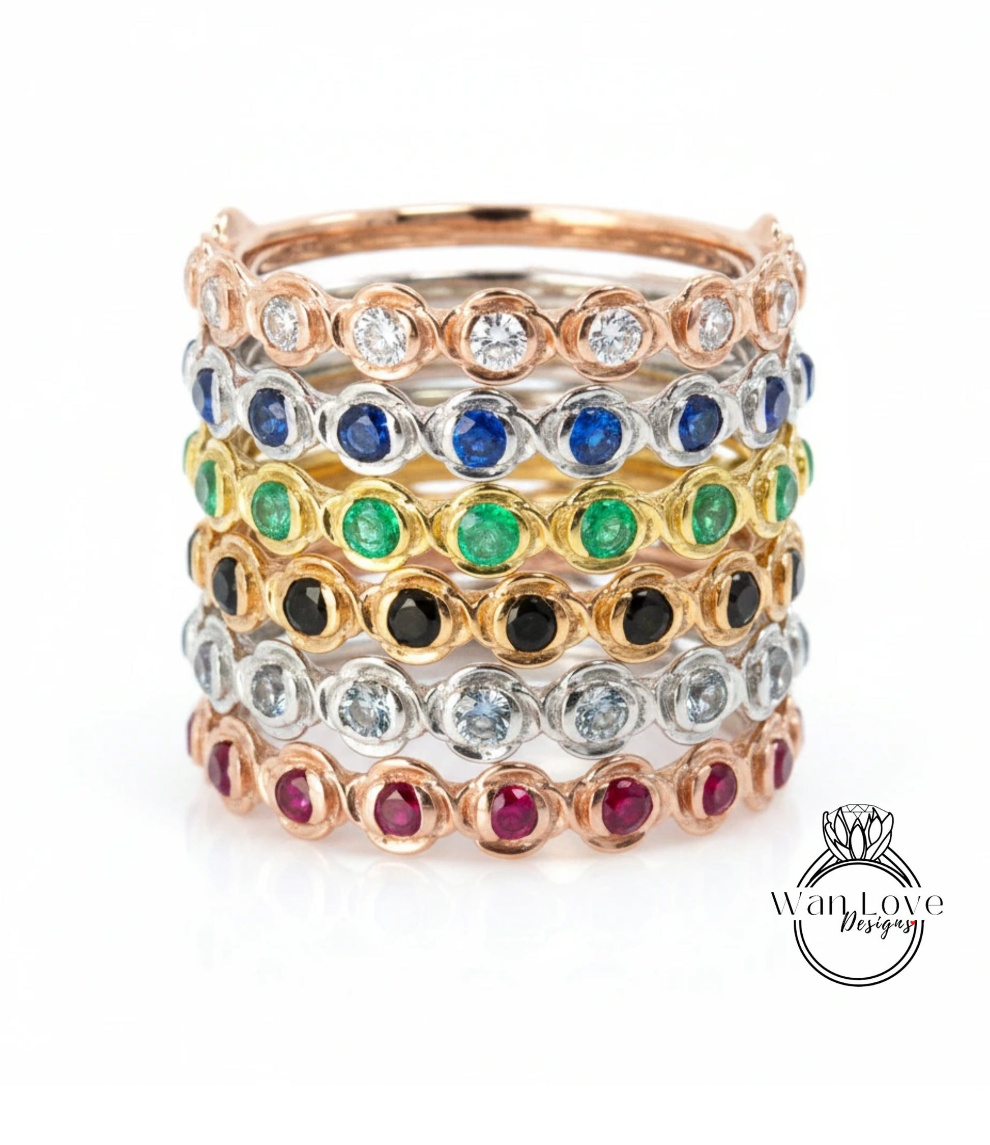 A stack of rings with various colored gemstones set in a metallic band.