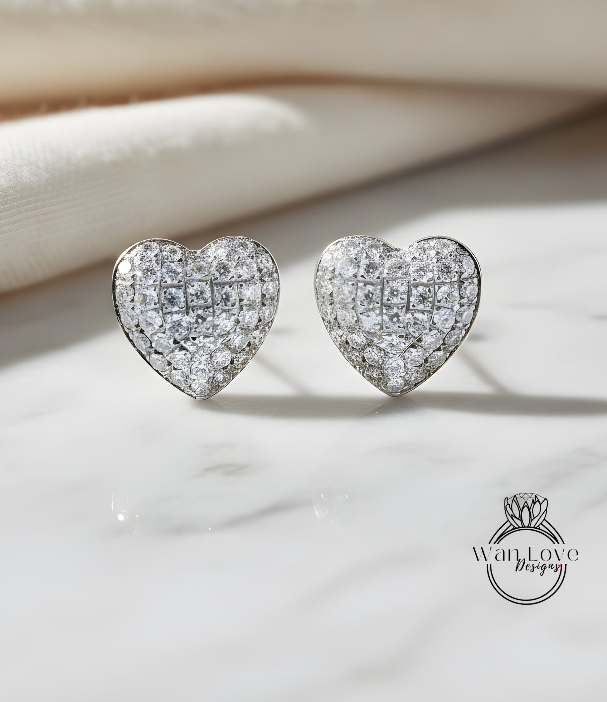 A pair of elegant diamond-encrusted heart-shaped earrings are displayed on a white marble surface, with a blurred background.