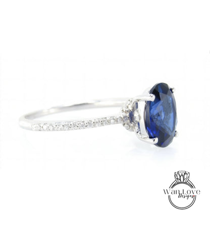 A close-up view of a silver ring with a large blue gemstone, likely a sapphire, set in the center.