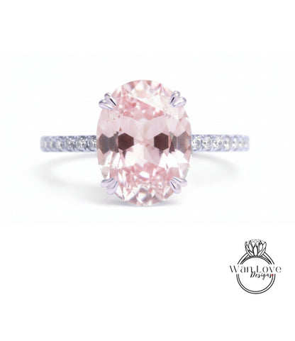 A pink gemstone engagement ring with a band and a logo for a jewelry designer.