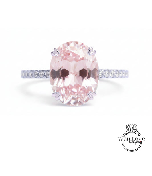 A pink gemstone engagement ring with a band and a logo for a jewelry designer.