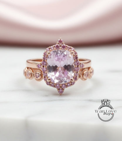 A close-up image of a pink gemstone ring with a large central gemstone surrounded by smaller gemstones and a halo of smaller gemstones around the central gemstone.