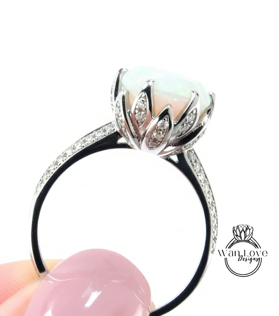 A close-up of a silver ring with a large opal gemstone, showcasing the intricate design and sparkling diamonds.