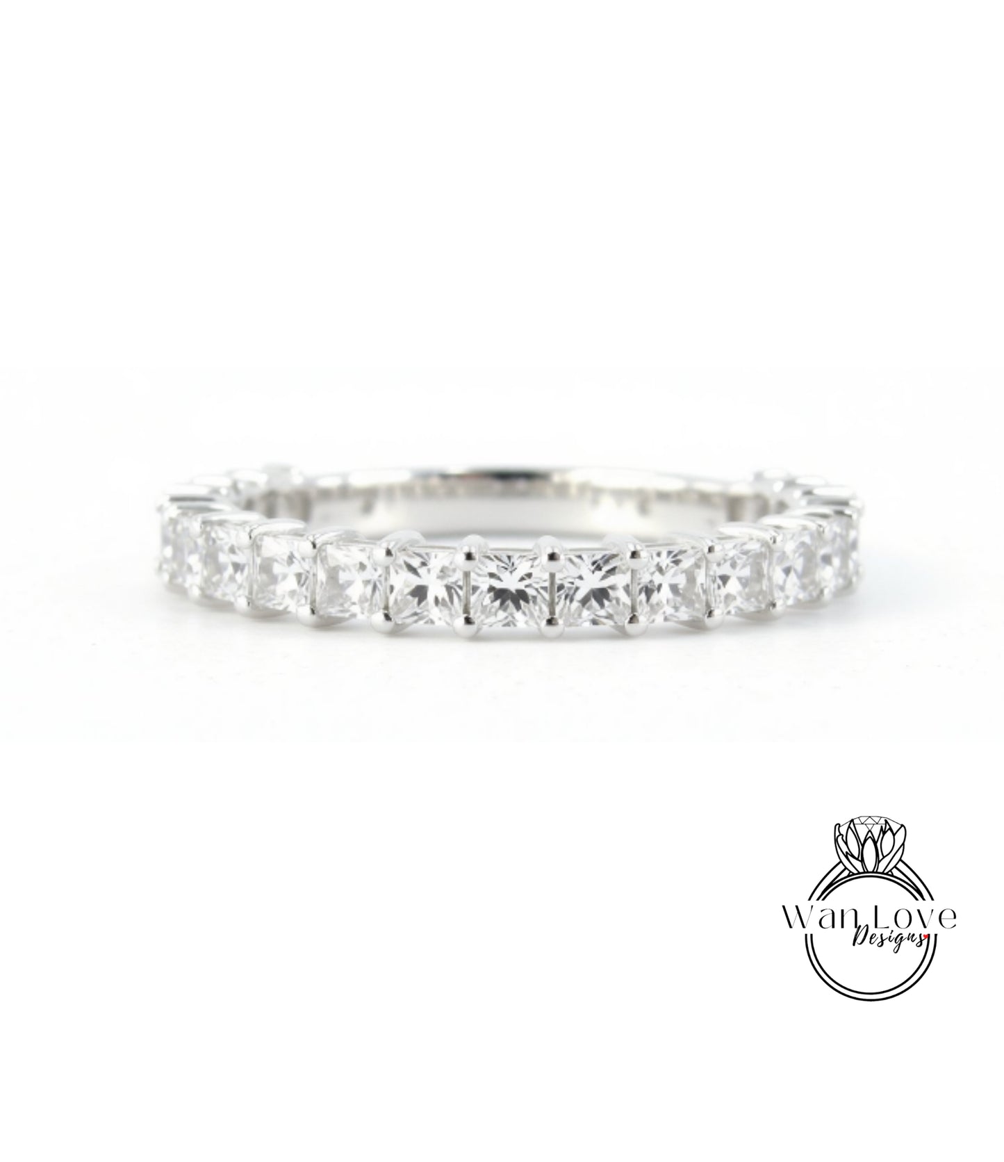 A diamond ring with a row of clear gemstones set in a silver band.