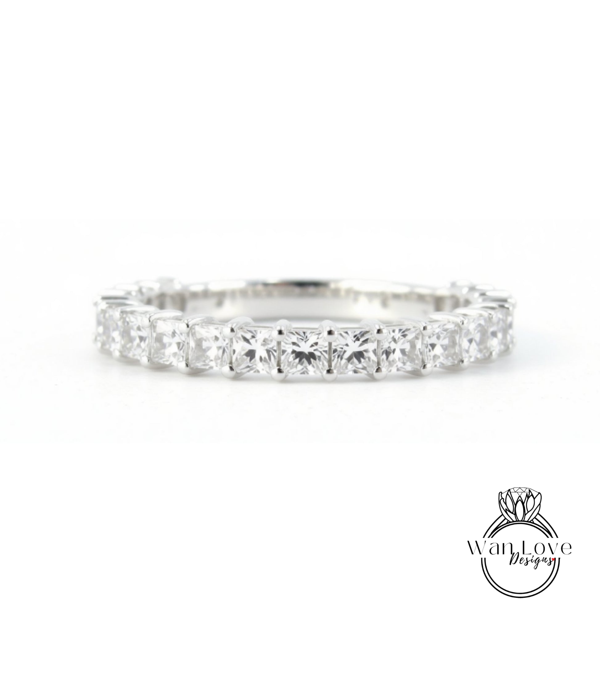 A diamond ring with a row of clear gemstones set in a silver band.