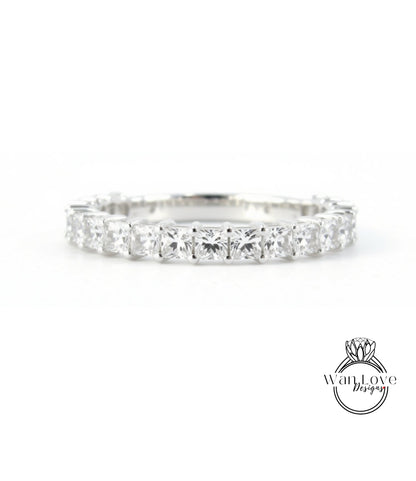 A diamond ring with a row of clear gemstones set in a silver band.
