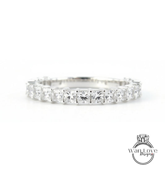 A diamond ring with a row of clear gemstones set in a silver band.