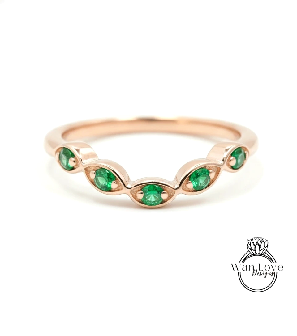 A rose gold ring with a row of green gemstones set in the center.