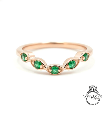 A rose gold ring with a row of green gemstones set in the center.