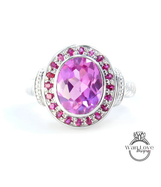 A ring with a large oval-shaped gemstone surrounded by a ring of smaller pink gemstones.